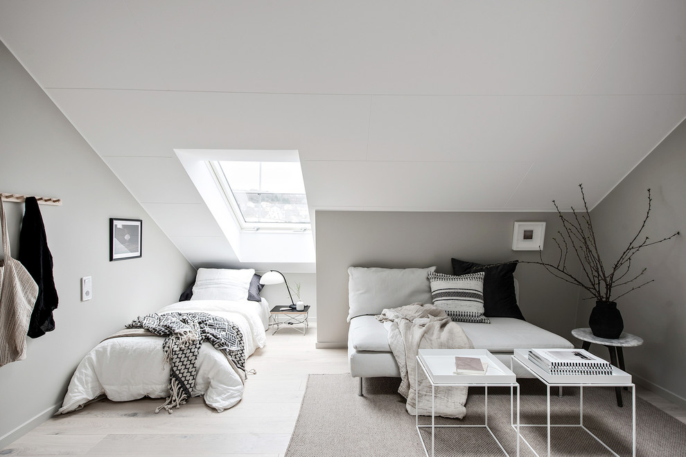 Bild på ett litet skandinaviskt sovrum, med grå väggar, ljust trägolv och grått golv