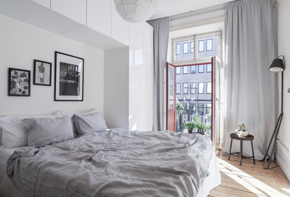 Inspiration pour une chambre parentale nordique de taille moyenne avec un mur blanc et parquet clair.