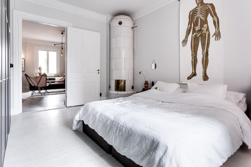 Großes Skandinavisches Hauptschlafzimmer ohne Kamin mit weißer Wandfarbe und gebeiztem Holzboden in Stockholm