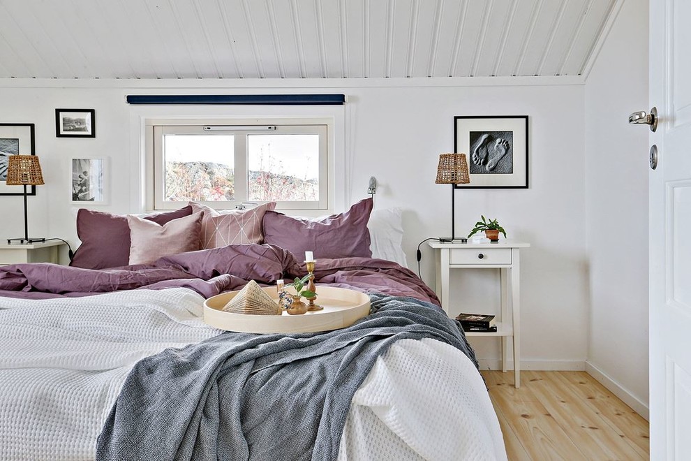 Landhaus Gästezimmer mit weißer Wandfarbe, hellem Holzboden und beigem Boden in Göteborg