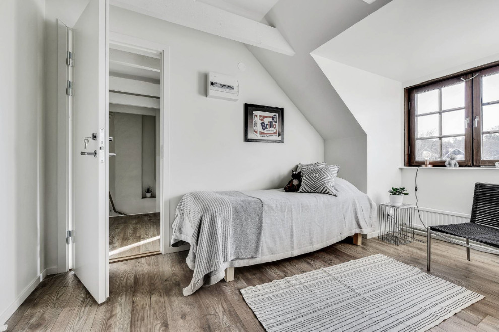 Inspiration för ett minimalistiskt sovrum, med vita väggar, mellanmörkt trägolv och brunt golv