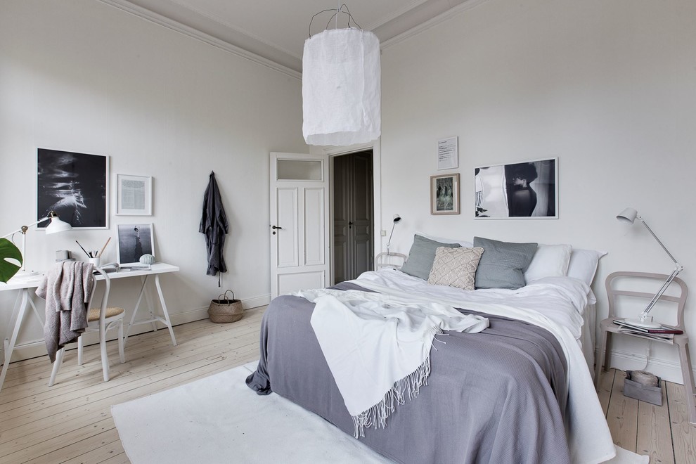 Foto di una camera da letto scandinava con pareti bianche, parquet chiaro e pavimento beige