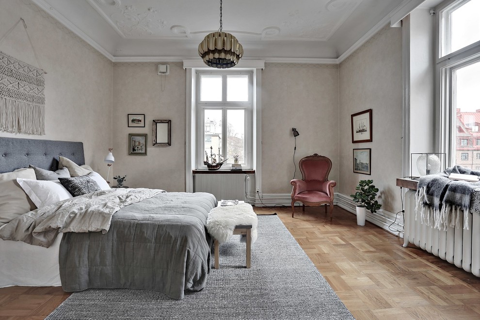 ヨーテボリにある巨大なヴィクトリアン調のおしゃれな主寝室 (ベージュの壁、淡色無垢フローリング)
