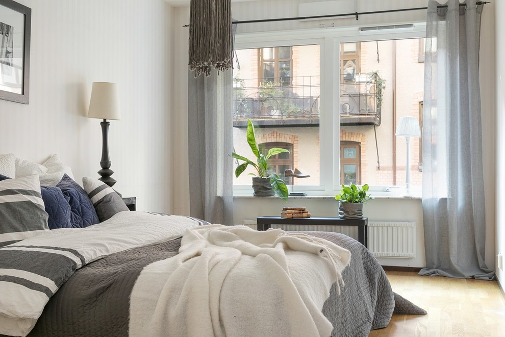 Exempel på ett minimalistiskt sovrum, med ljust trägolv, beiget golv och beige väggar