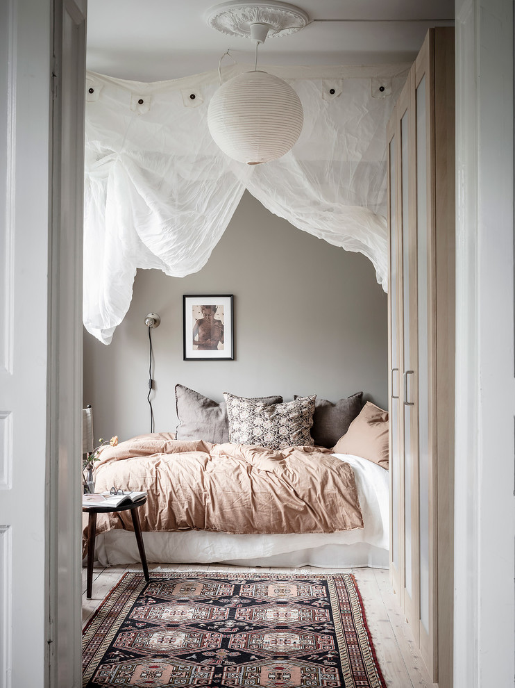 Cette photo montre une chambre d'amis scandinave avec un mur gris, parquet clair et un sol beige.