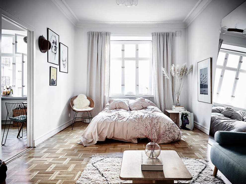 Mittelgroßes Skandinavisches Hauptschlafzimmer ohne Kamin mit weißer Wandfarbe, braunem Holzboden und braunem Boden in Göteborg