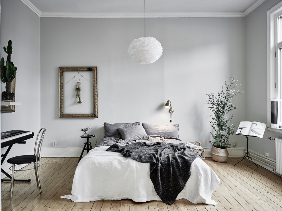 На фото: большая хозяйская спальня в скандинавском стиле с серыми стенами и светлым паркетным полом без камина
