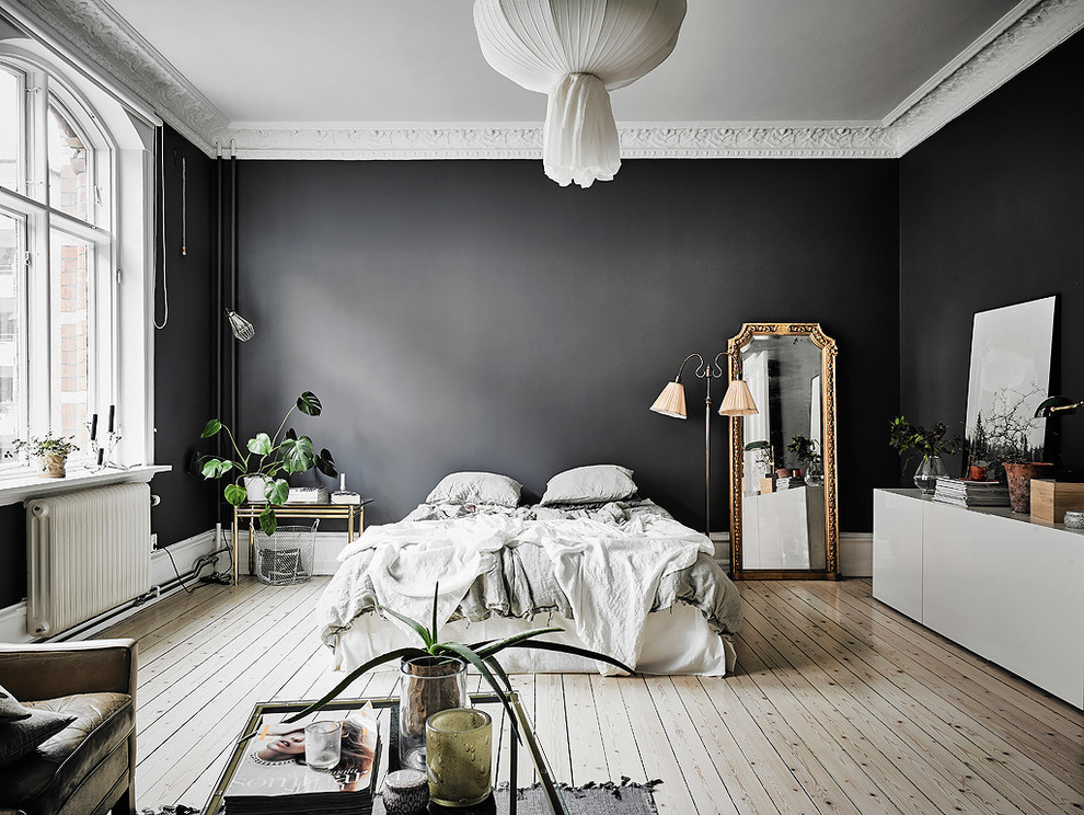 ヨーテボリにある巨大な北欧スタイルのおしゃれな主寝室 (黒い壁、淡色無垢フローリング、暖炉なし) のインテリア
