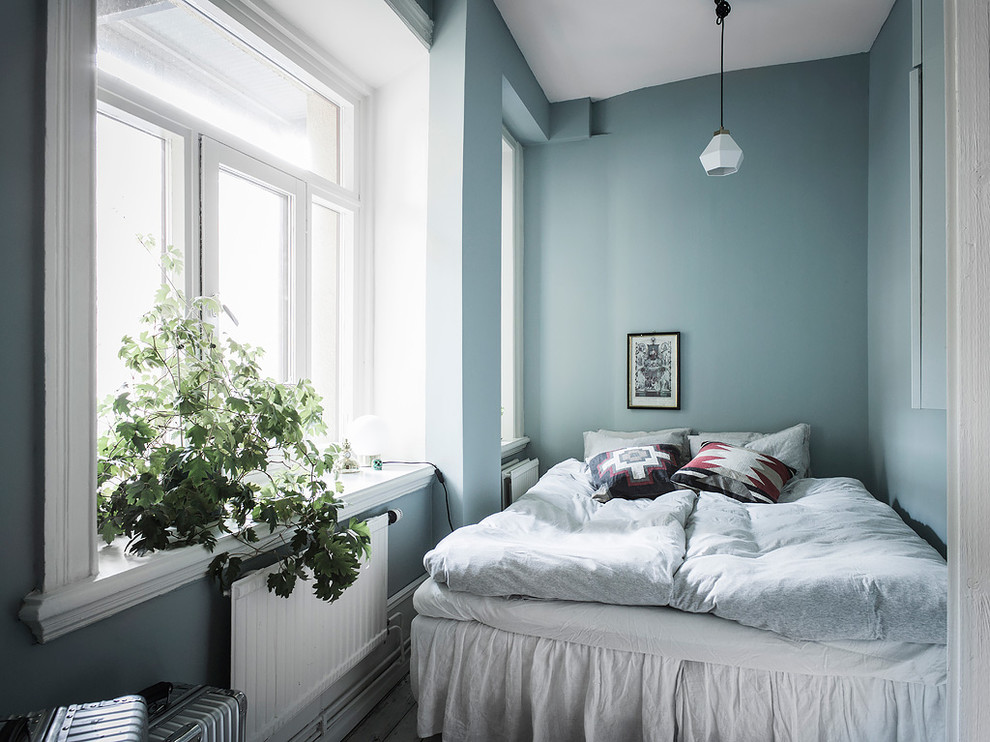 Small scandinavian master bedroom in Gothenburg with blue walls.