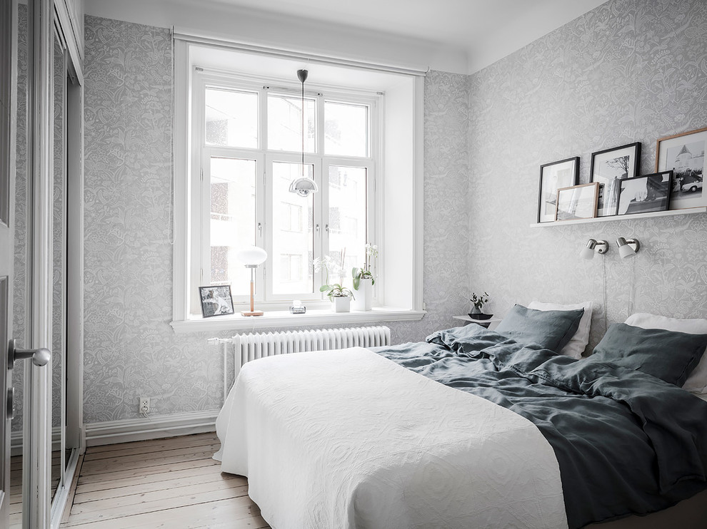 Diseño de dormitorio nórdico con paredes grises, suelo de madera clara y suelo beige