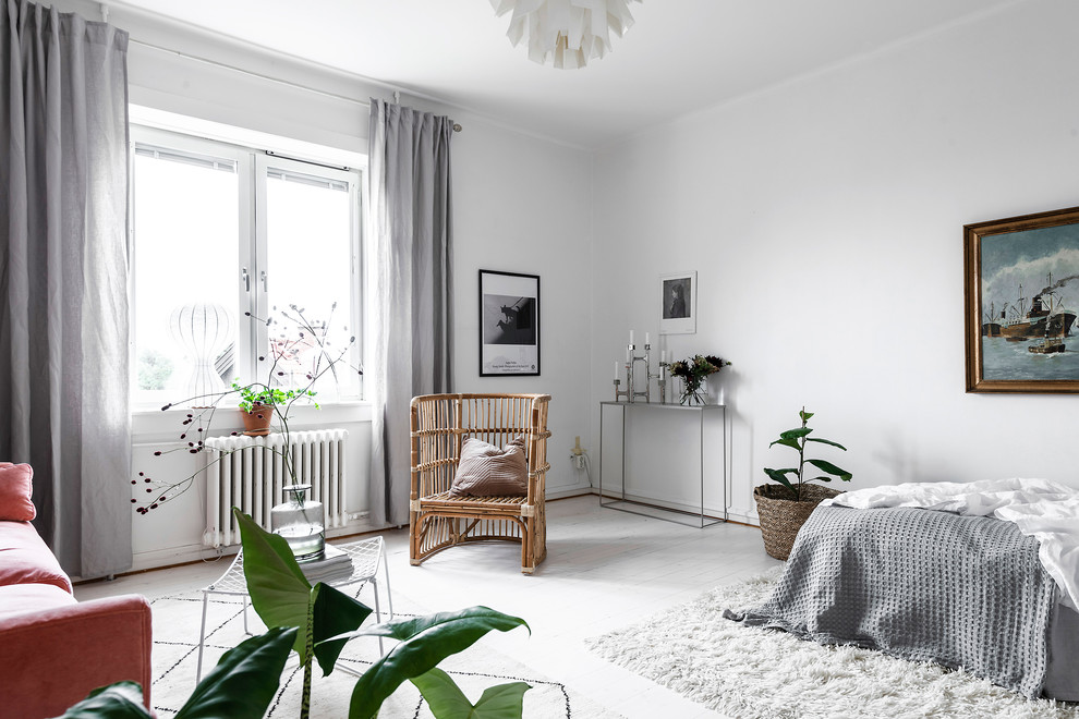 Inredning av ett skandinaviskt sovrum, med vita väggar, målat trägolv och vitt golv