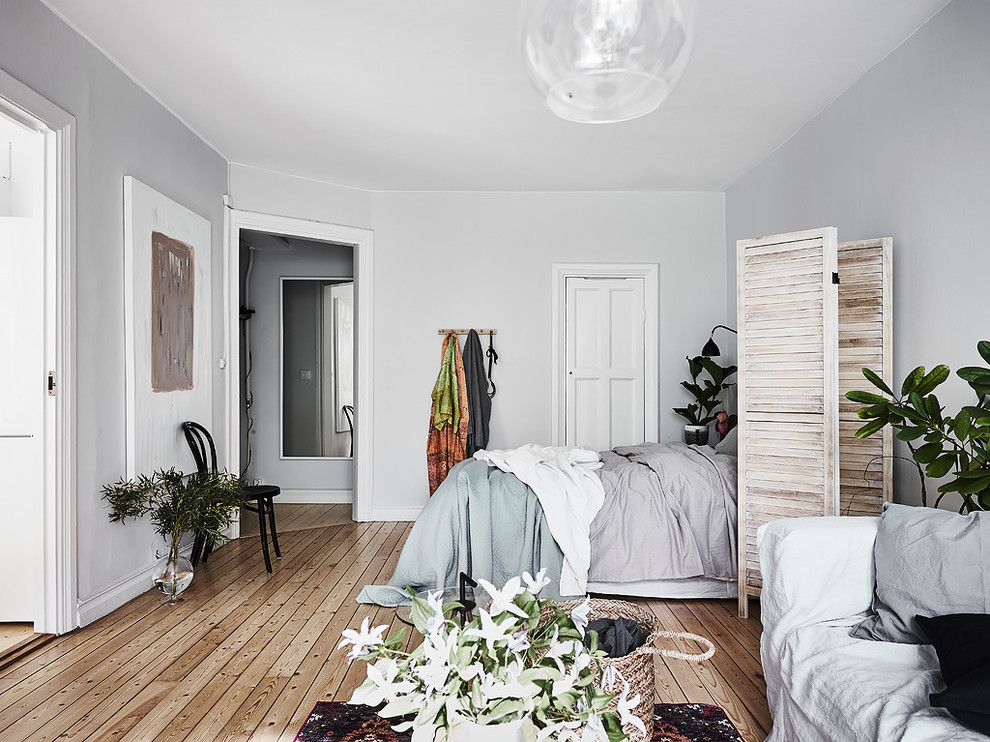 Idéer för ett minimalistiskt sovrum, med vita väggar och ljust trägolv