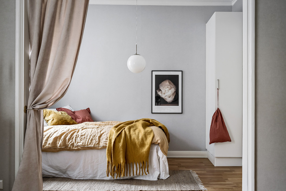 Inspiration för ett litet minimalistiskt sovrum, med grå väggar och mellanmörkt trägolv