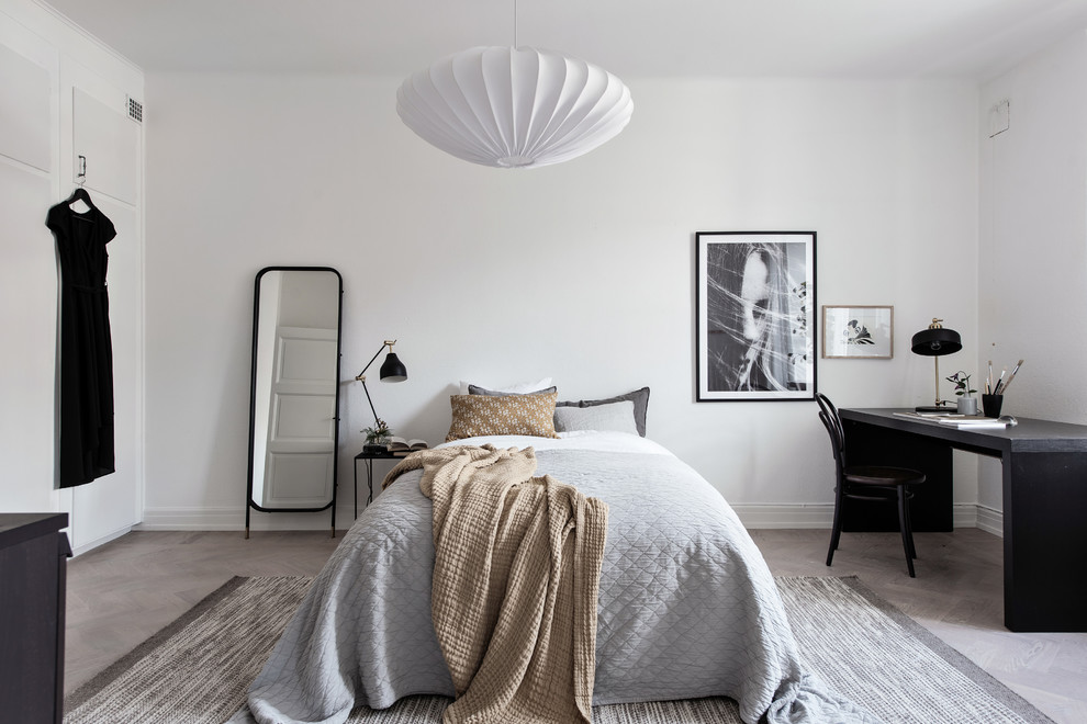Inspiration for a scandinavian guest bedroom in Gothenburg with white walls, medium hardwood flooring and beige floors.
