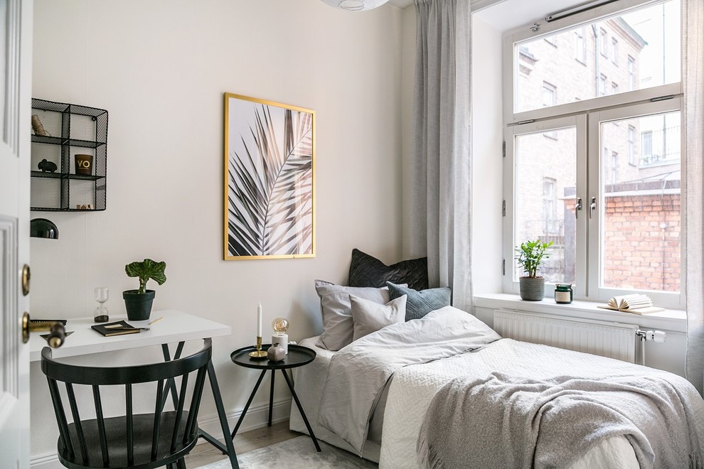 ストックホルムにある小さな北欧スタイルのおしゃれな客用寝室 (白い壁、ベージュの床、淡色無垢フローリング) のレイアウト