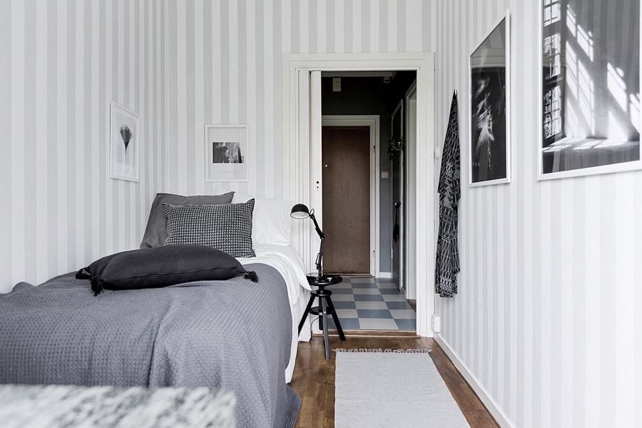 Cette photo montre une petite chambre scandinave avec un mur multicolore et parquet foncé.