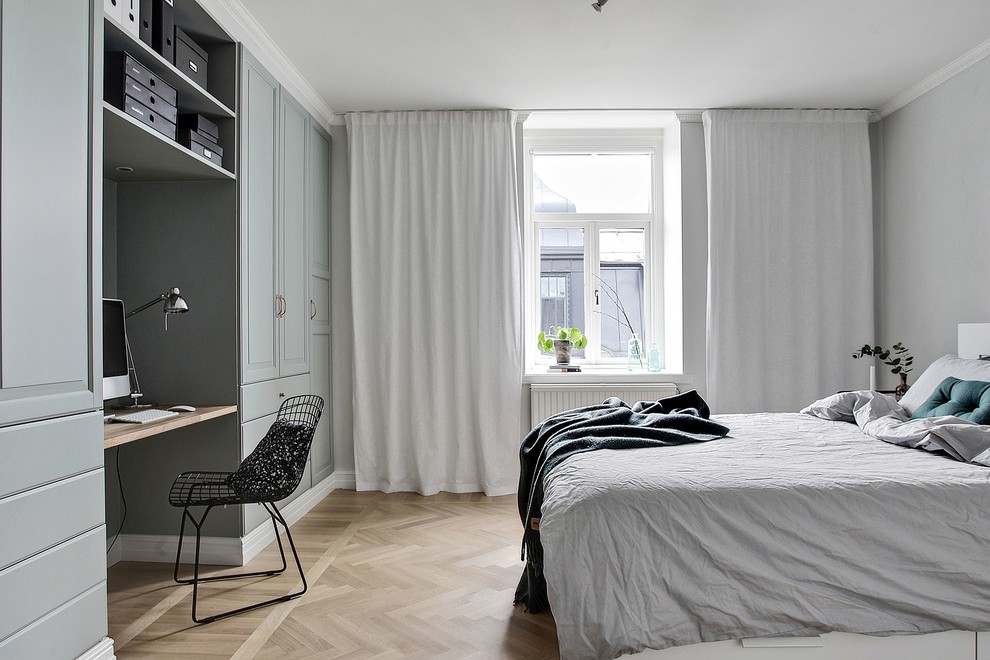 Large scandi master bedroom in Other with grey walls, light hardwood flooring and beige floors.