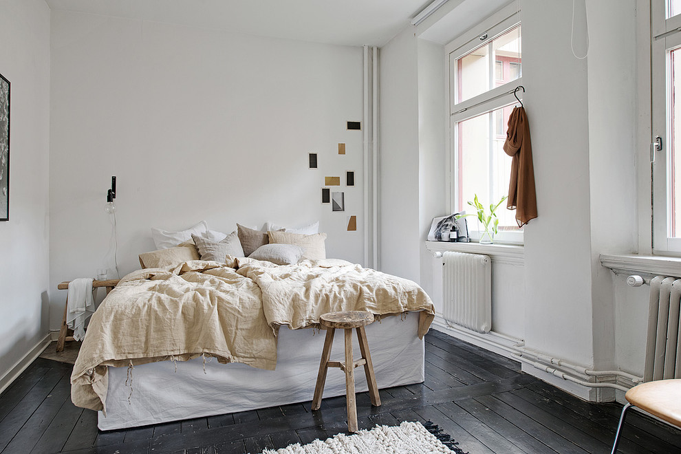 Medium sized scandi master bedroom in Gothenburg with white walls, painted wood flooring and no fireplace.