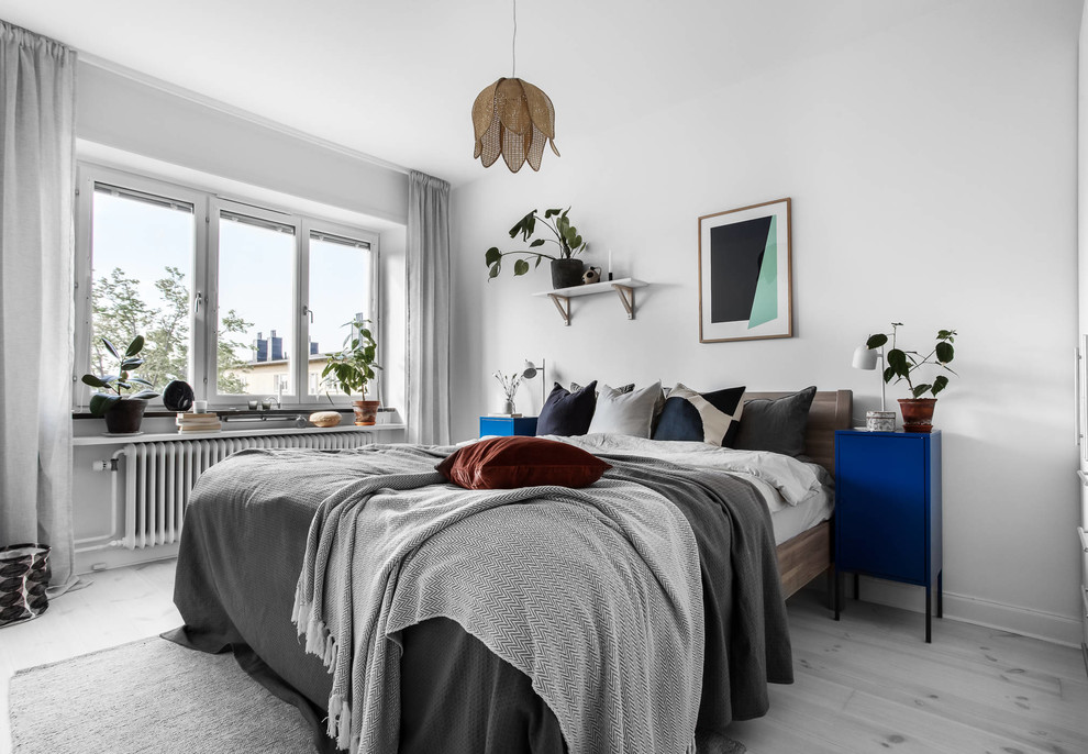 На фото: хозяйская спальня среднего размера в скандинавском стиле с белыми стенами, светлым паркетным полом и серым полом без камина с