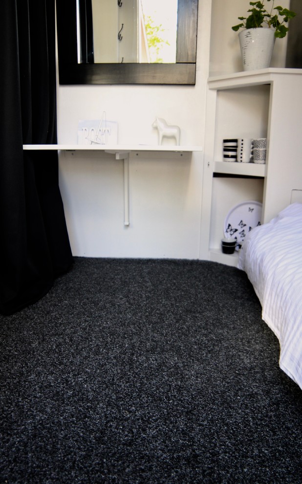 This is an example of a small scandi guest bedroom in Other with white walls, carpet and grey floors.