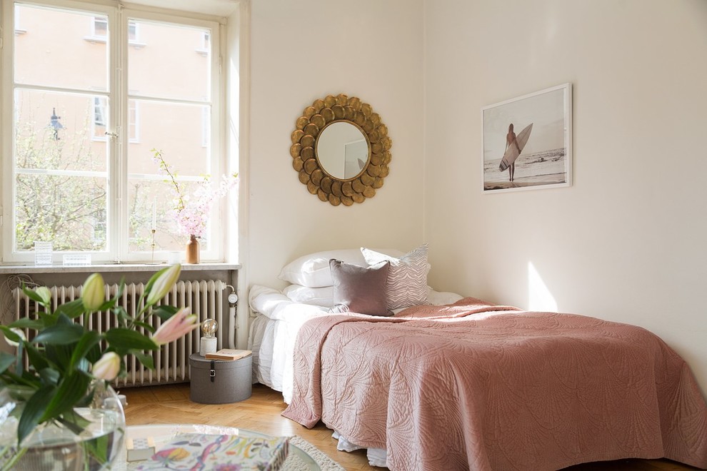 Danish medium tone wood floor bedroom photo in Stockholm with white walls