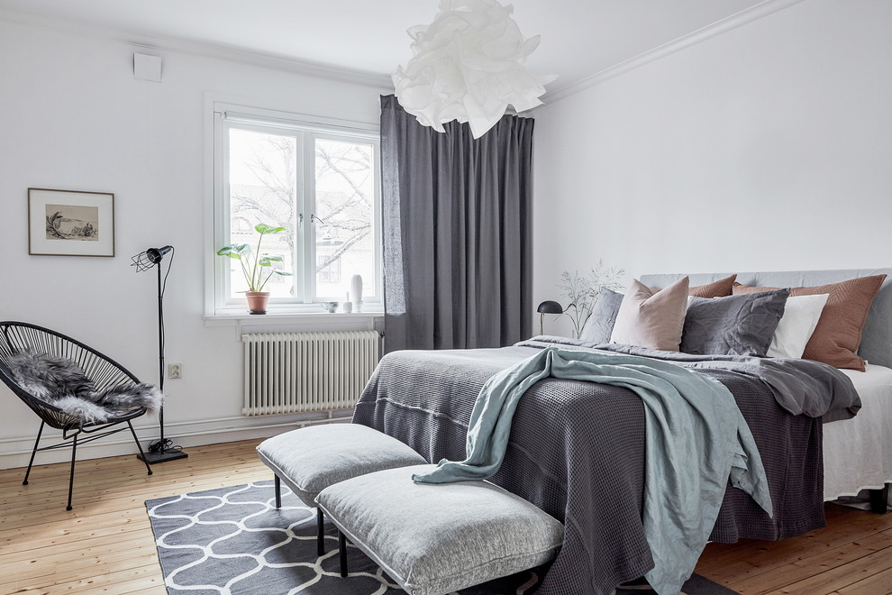 Idées déco pour une chambre parentale grise et rose scandinave de taille moyenne avec un mur blanc, un sol beige, parquet clair et aucune cheminée.