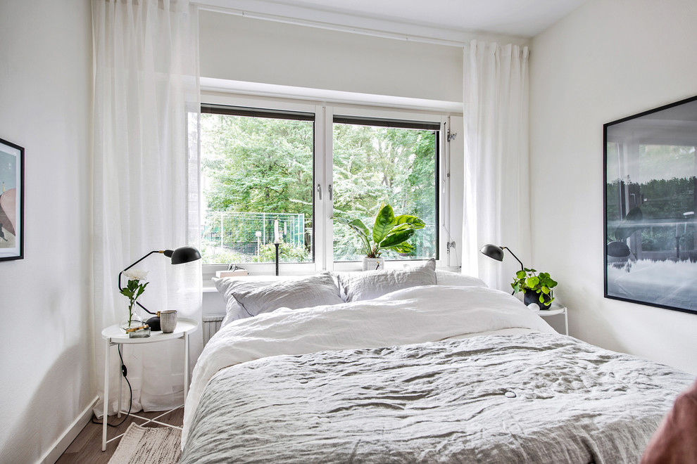 Ejemplo de dormitorio principal nórdico con paredes blancas