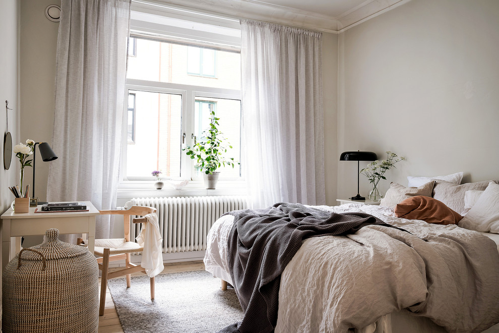 Exempel på ett nordiskt sovrum, med beige väggar, ljust trägolv och beiget golv