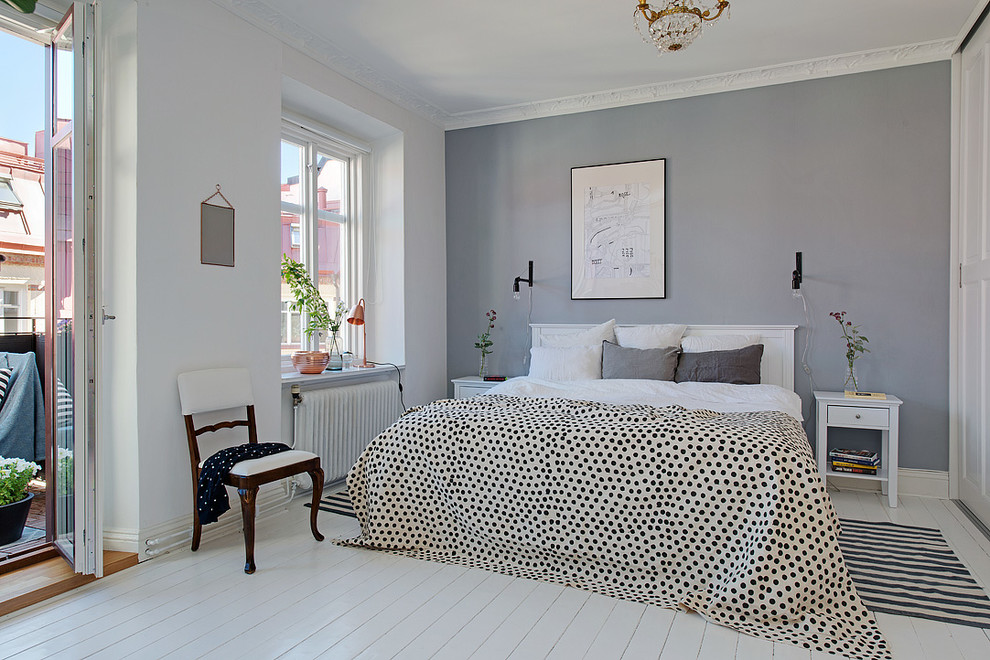 На фото: хозяйская спальня среднего размера в скандинавском стиле с белыми стенами и деревянным полом без камина