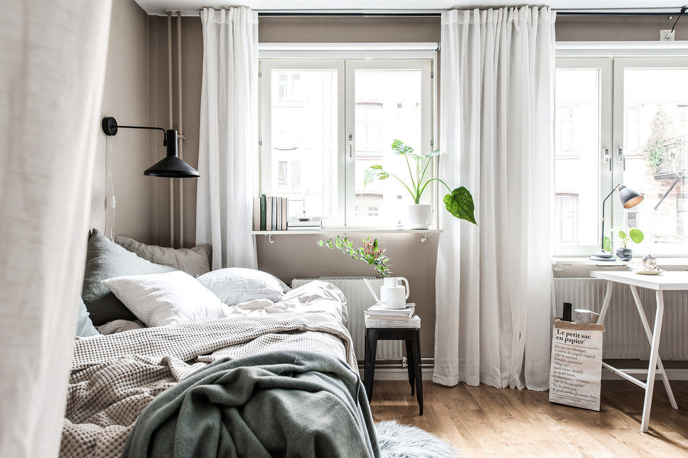 Imagen de dormitorio nórdico con paredes marrones, suelo de madera en tonos medios y suelo marrón
