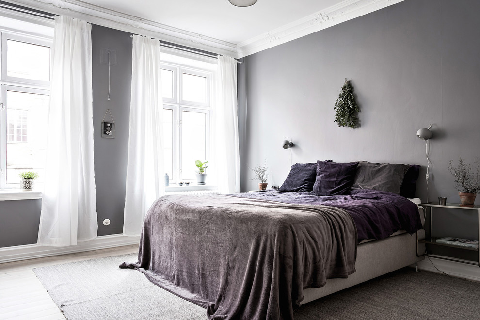 Skandinavisches Schlafzimmer mit grauer Wandfarbe und hellem Holzboden in Göteborg