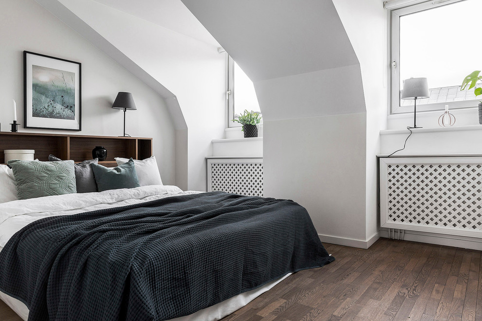 Foto di un'In mansarda camera da letto scandinava con pareti bianche, pavimento in legno massello medio e pavimento marrone