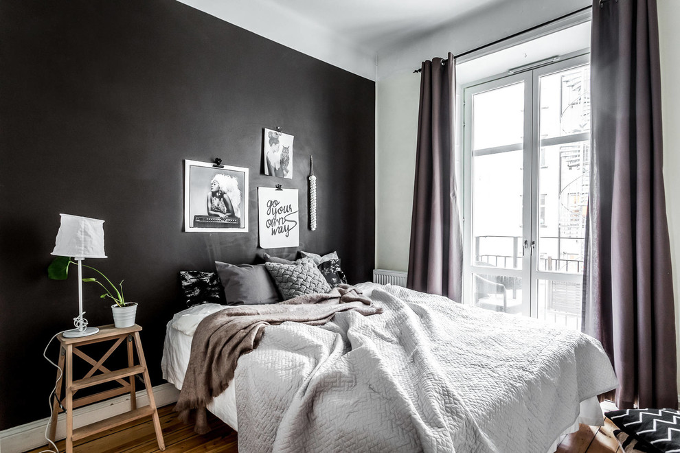 На фото: хозяйская спальня среднего размера в скандинавском стиле с черными стенами и темным паркетным полом