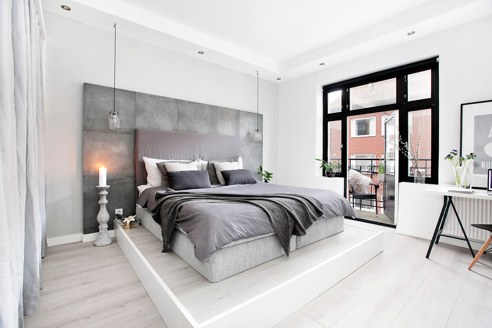 Imagen de dormitorio principal escandinavo de tamaño medio sin chimenea con paredes blancas y suelo de madera pintada