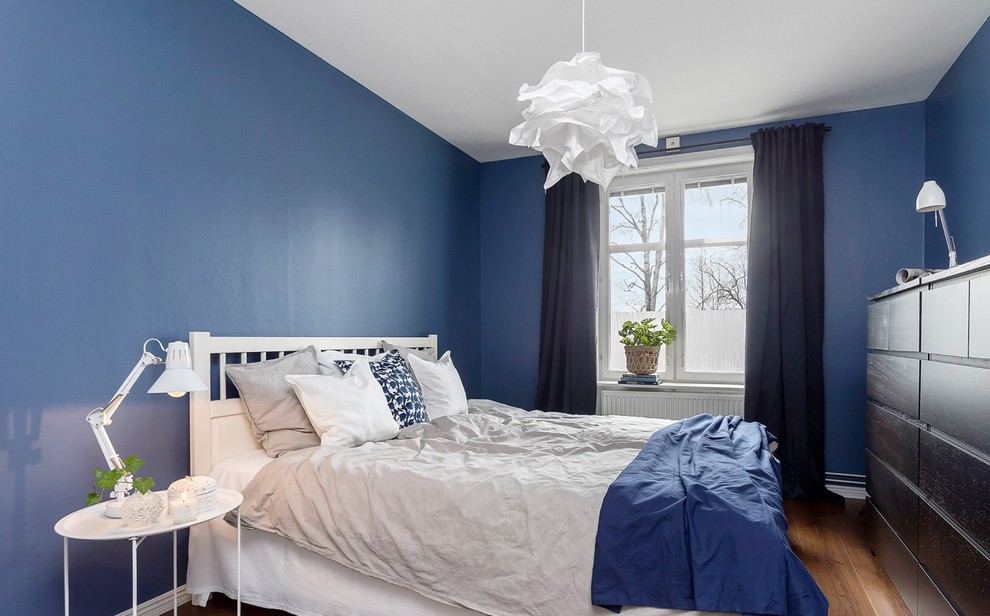 Пример оригинального дизайна: гостевая спальня (комната для гостей) в скандинавском стиле с синими стенами, паркетным полом среднего тона и коричневым полом
