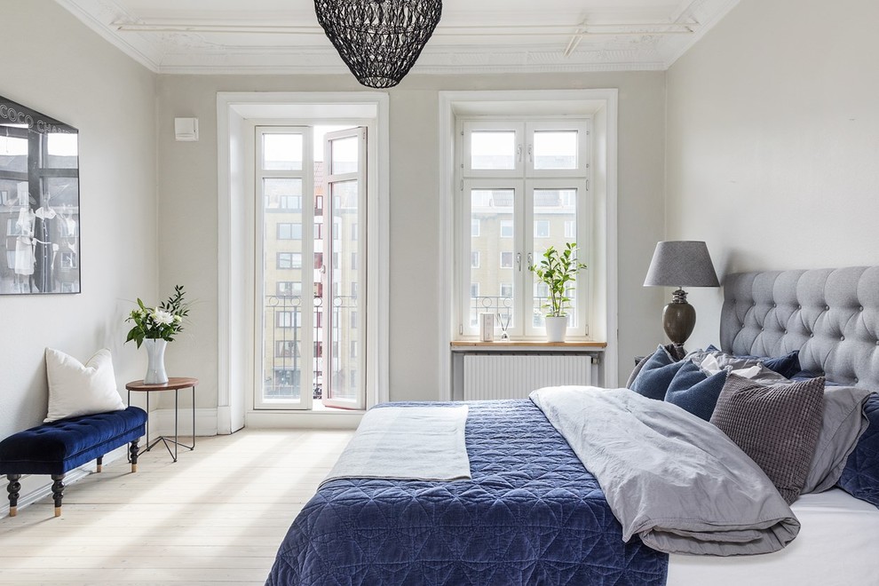 Imagen de dormitorio principal escandinavo grande con paredes grises, suelo de madera clara y suelo beige
