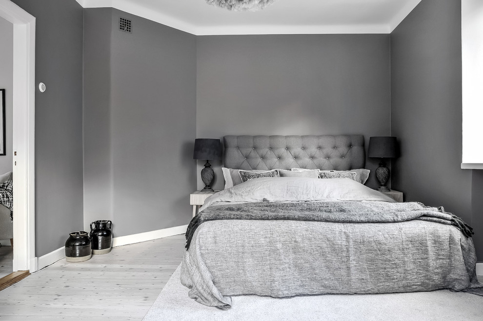 Imagen de dormitorio principal escandinavo de tamaño medio con paredes grises y suelo de madera pintada