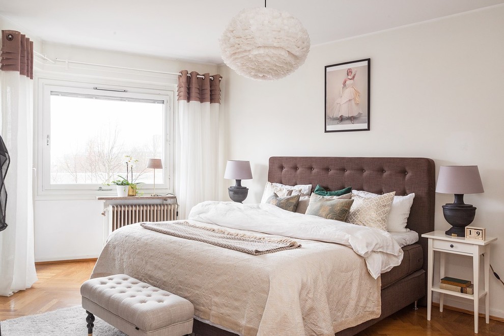 Medium sized scandinavian bedroom in Gothenburg with white walls, medium hardwood flooring and brown floors.