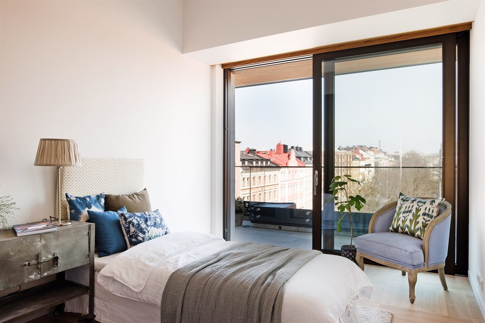 Großes Modernes Hauptschlafzimmer ohne Kamin mit weißer Wandfarbe und hellem Holzboden in Stockholm