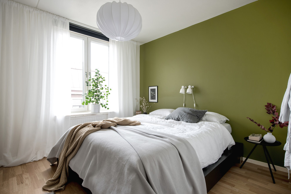 This is an example of a scandi bedroom in Gothenburg with white walls, light hardwood flooring and beige floors.