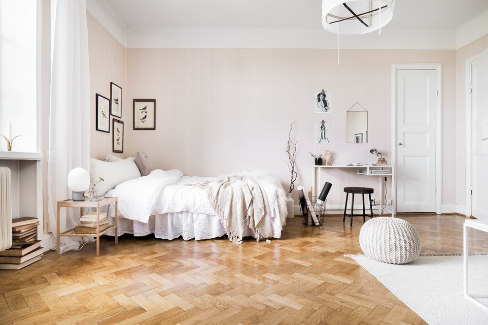 Photo of a medium sized scandinavian master bedroom in Stockholm with pink walls and medium hardwood flooring.