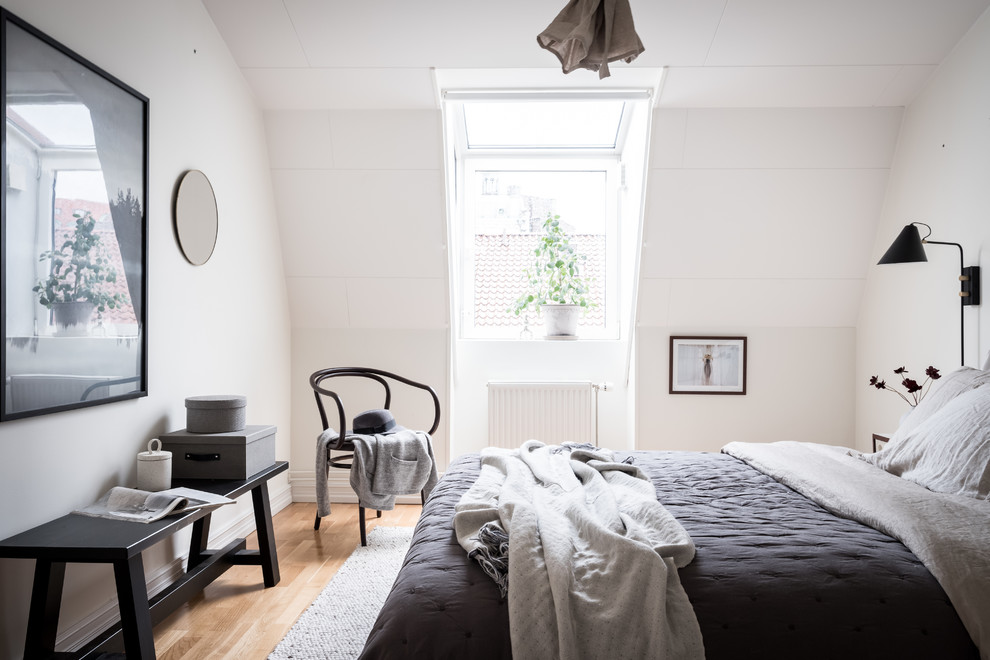Foto de dormitorio principal nórdico con paredes blancas, suelo de madera en tonos medios y suelo beige