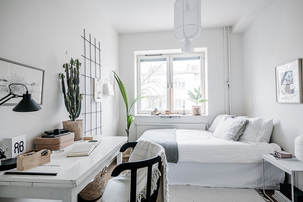 Nordisches Schlafzimmer mit weißer Wandfarbe, dunklem Holzboden und braunem Boden in Stockholm