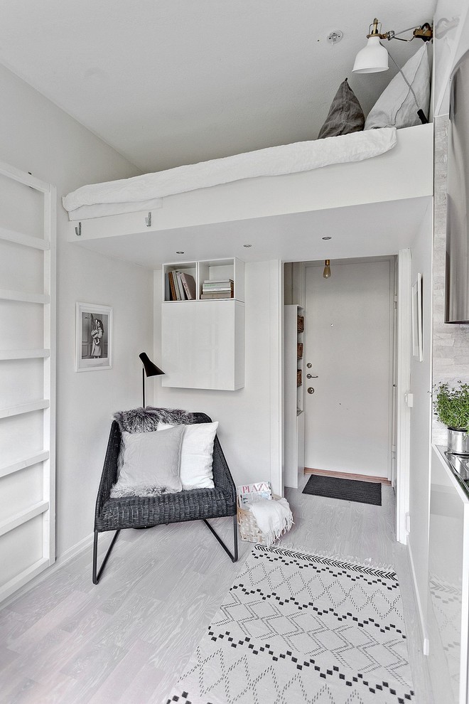 Idée de décoration pour une chambre parentale nordique de taille moyenne avec un mur blanc et parquet peint.