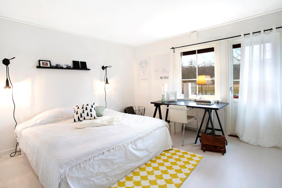 Diseño de dormitorio principal escandinavo de tamaño medio sin chimenea con paredes blancas, suelo de madera clara y con escritorio