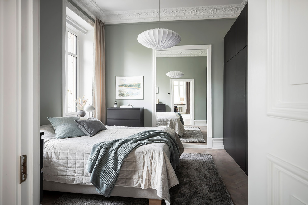 Minimalistisk inredning av ett sovrum, med grå väggar, ljust trägolv och beiget golv