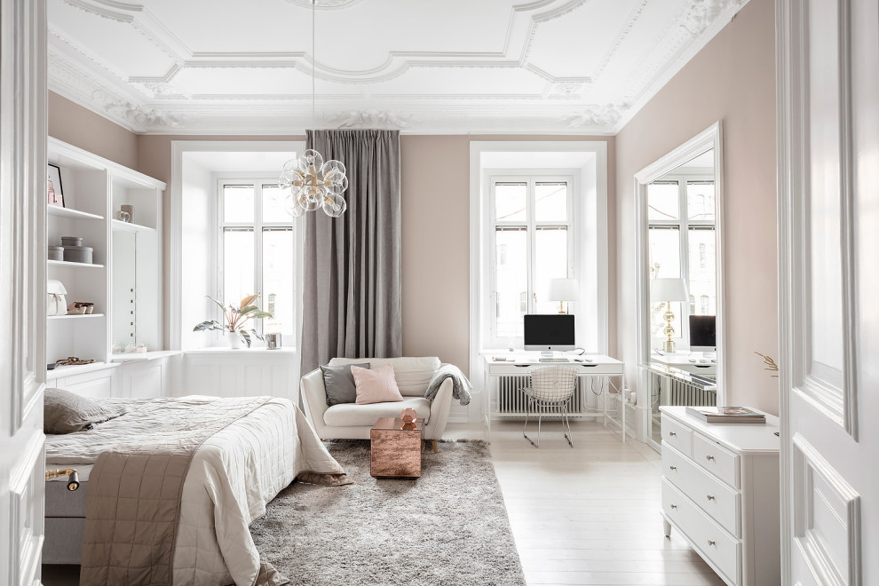 Immagine di una camera da letto nordica con pareti beige, parquet chiaro e pavimento beige