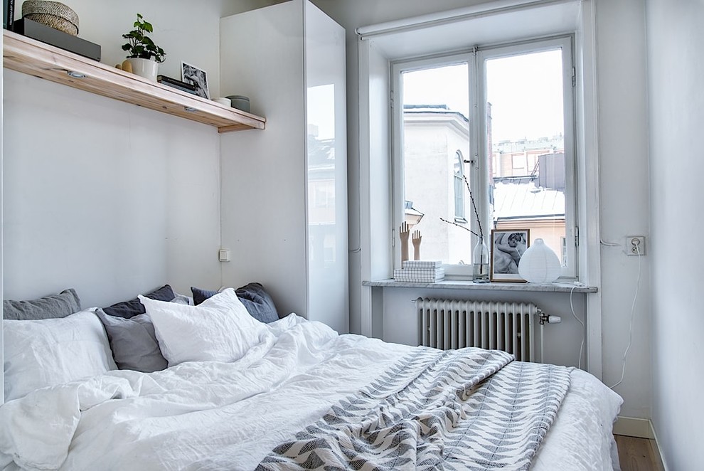 Cette photo montre une petite chambre parentale scandinave avec un mur blanc, parquet clair et aucune cheminée.