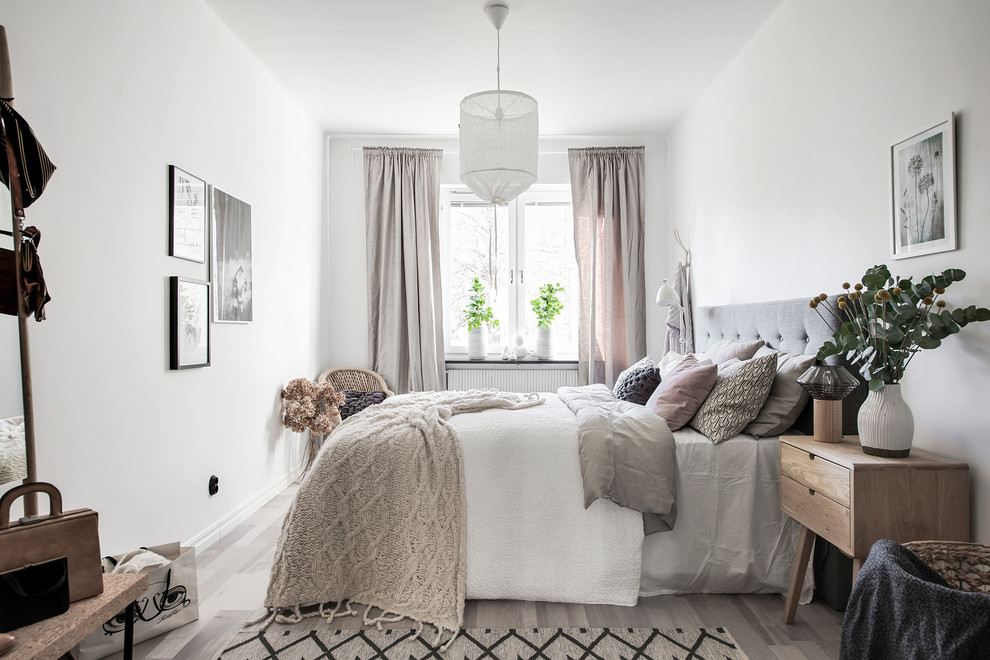 Стильный дизайн: хозяйская спальня в скандинавском стиле с белыми стенами и светлым паркетным полом без камина - последний тренд