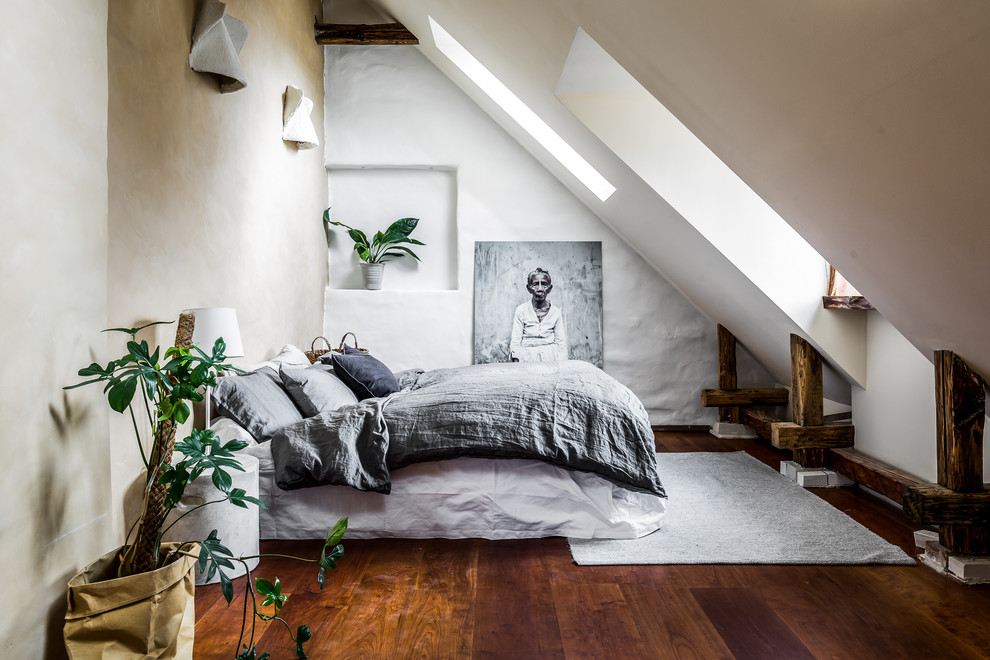 Diseño de dormitorio nórdico con paredes blancas, suelo de madera en tonos medios y suelo marrón